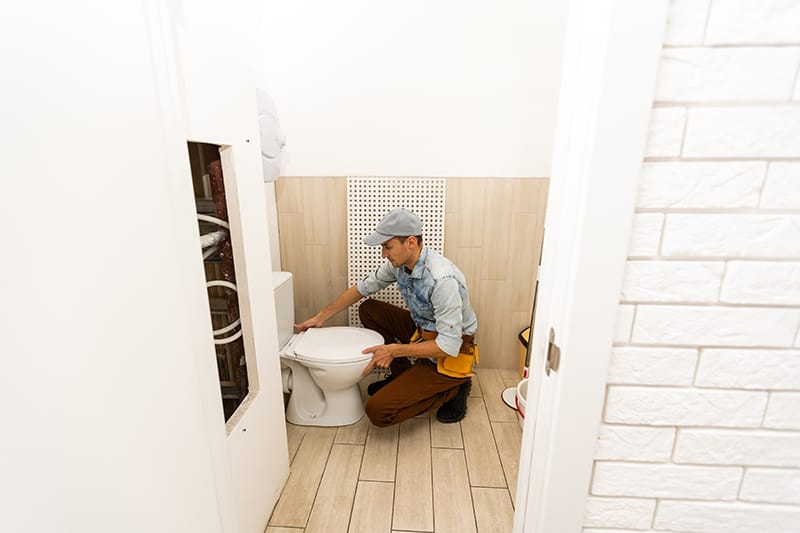Plumber Fixing The Toilet Issue